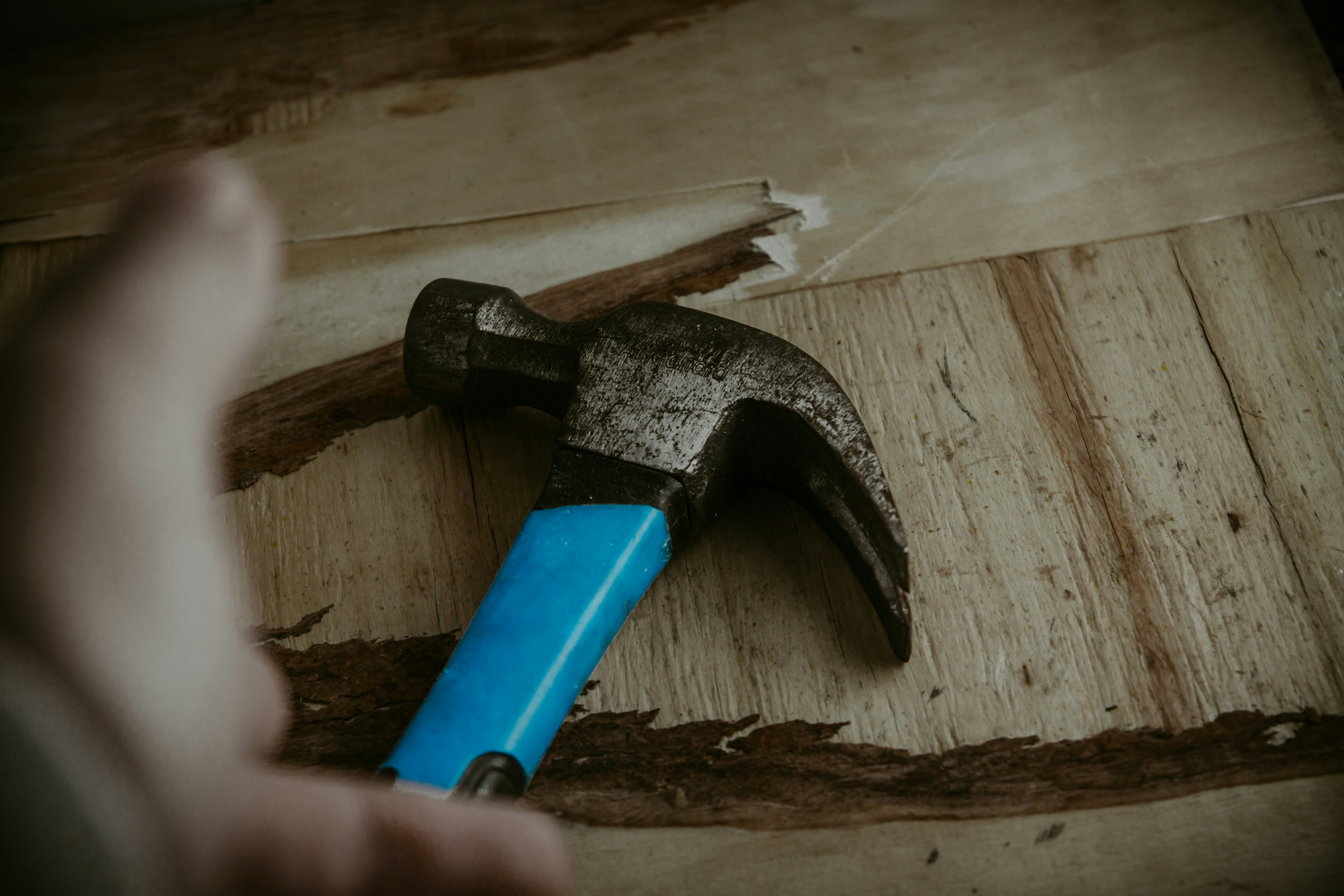 Vakkundige timmerman van DHB Bouw B.V. die nauwkeurig een spijker in hout slaat, illustratief voor de vacature voor zelfstandige timmerman bij ons bouwproject.